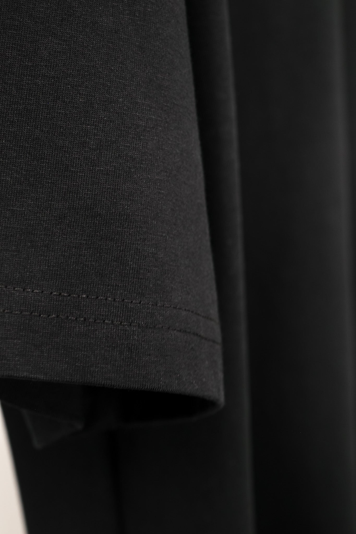Close-up of a dark gray fabric with a focus on texture and stitching.