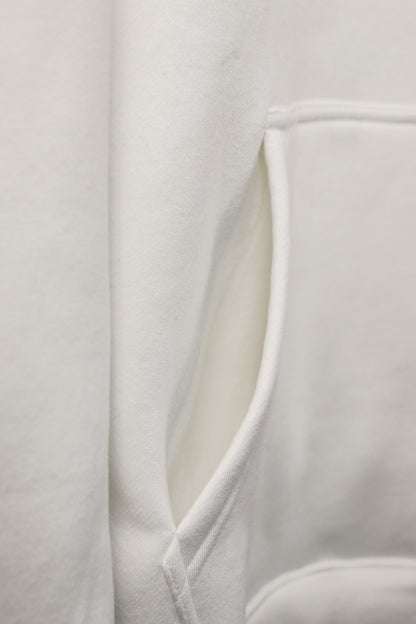 Close-up of a white garment with a V-neckline on a light gray background