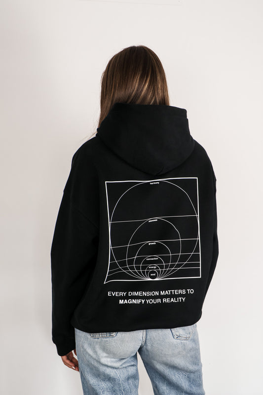 Person wearing a black hoodie with a mathematical design and text on the back, standing against a plain background.