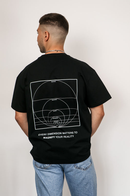 Person wearing a black t-shirt with a geometric design and text on the back, standing against a plain background.