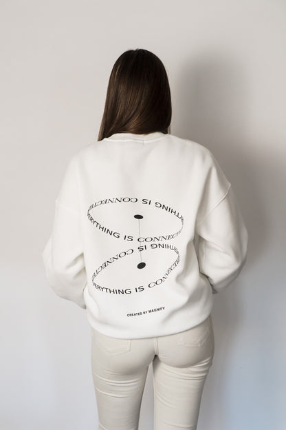 Person wearing a white sweatshirt with text design on the back against a plain background