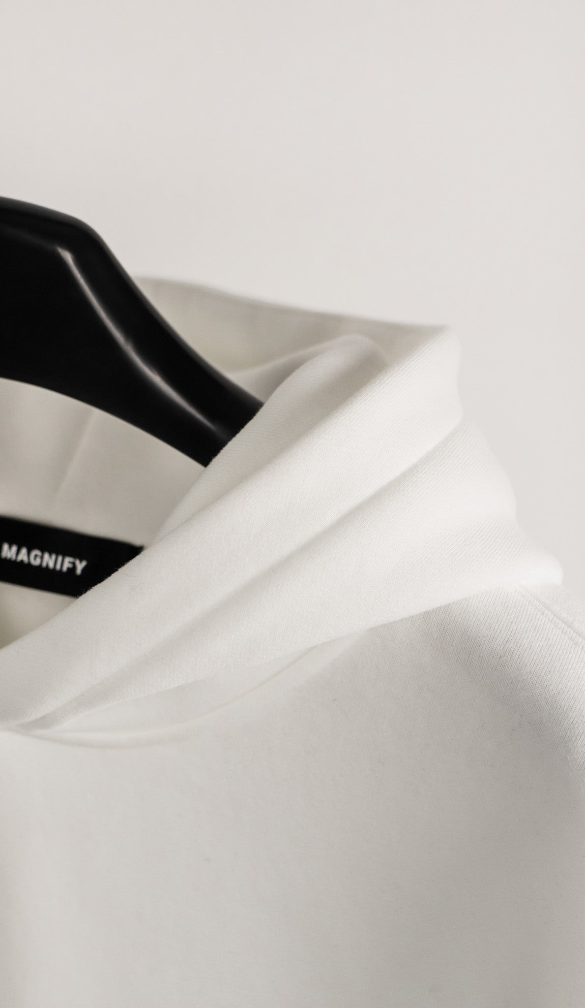 White satin fabric with a black hanger on a light gray background